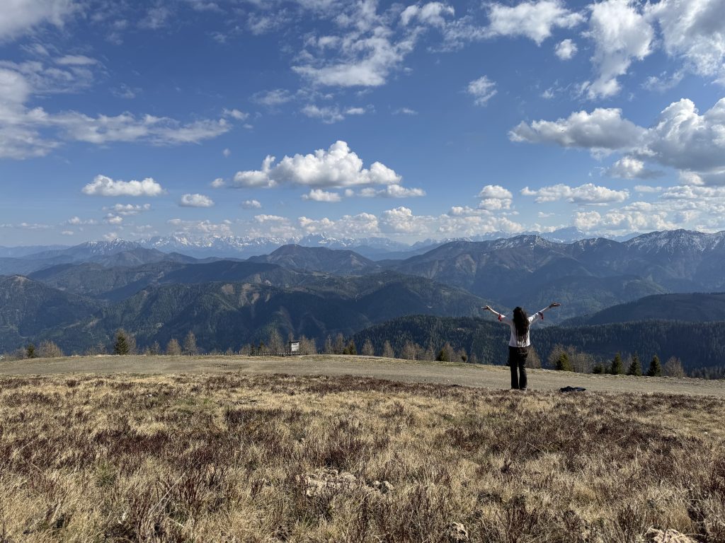 Photo of Sharon in the Alps with her arms flung out wide in worship